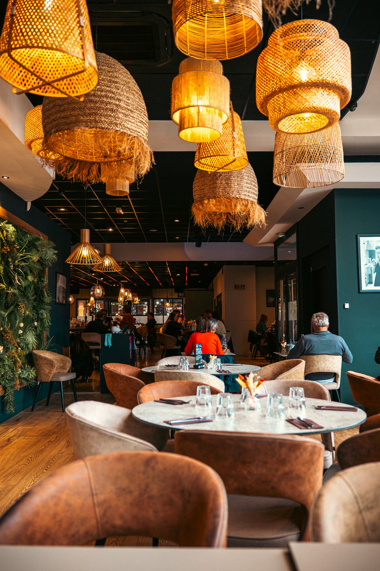 alle du restaurant WOODS à Bourgoin-Jallieu avec décoration végétale, murs verts et lumières tamisées ambiance chic.